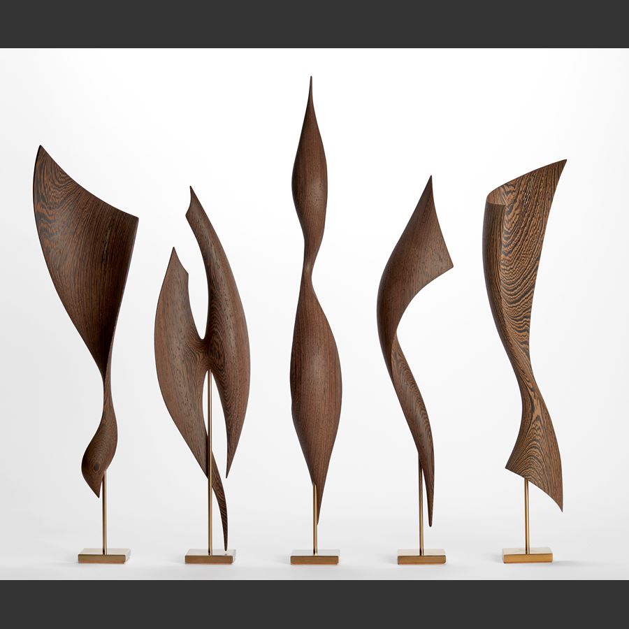 rich dark wenge wood sculpture with swirling dark wood grain and the appearance of an elegant brancusi inspired sleek upright stylised bird with inlaid gold detail and gold plated stand 