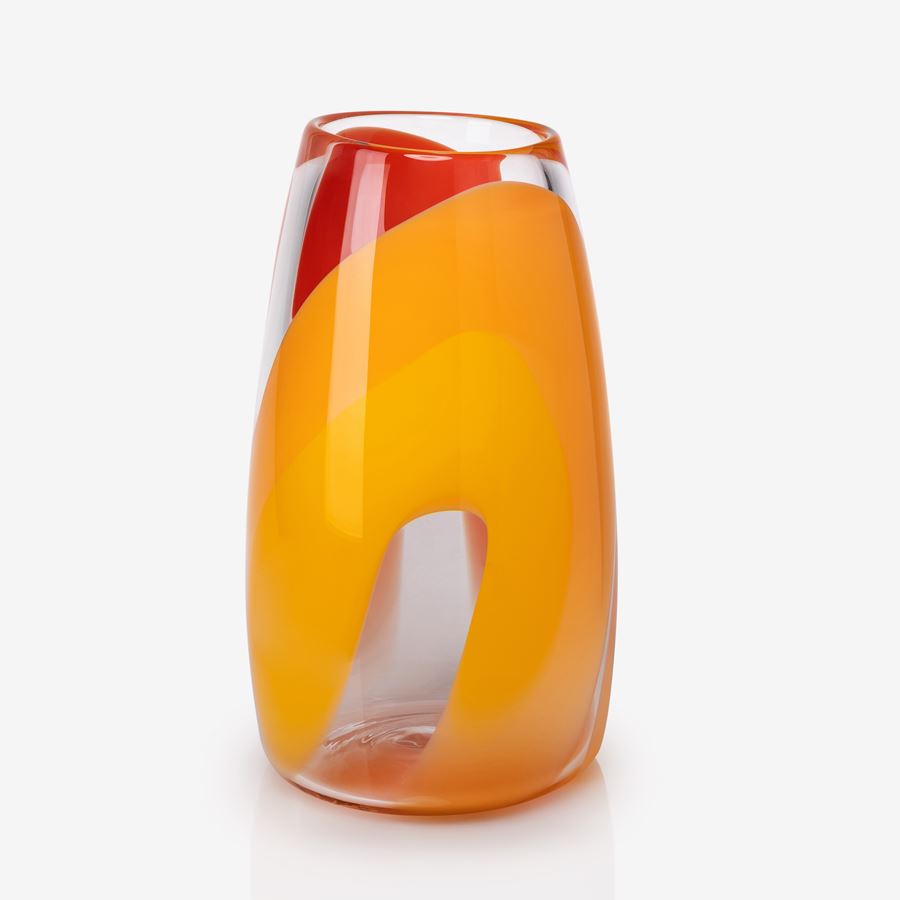 soft stumpy cylinder vase with gently curved sides in clear with intense wide looping bands of colour in yellow gold and red hand made and blown from glass