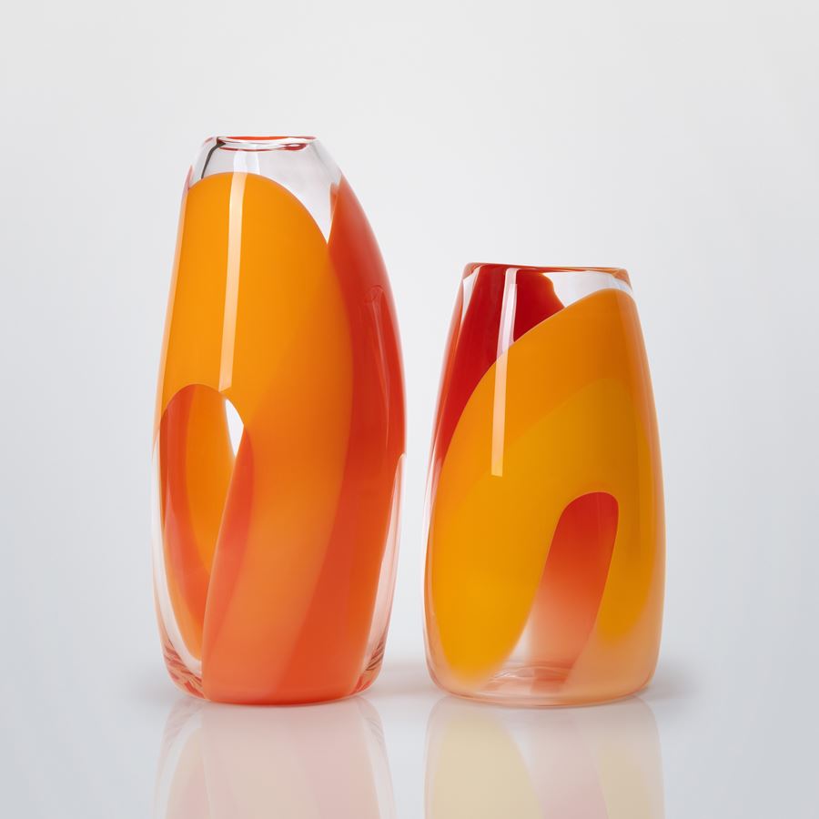 soft stumpy cylinder vase with gently curved sides in clear with intense wide looping bands of colour in yellow gold and red hand made and blown from glass