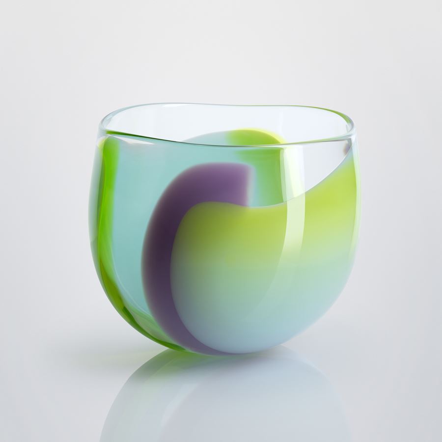 tulip flower shaped hand blown clear glass bowl with swirling merging bands and sections of colour in opaque lime purple and aquamarine blue 