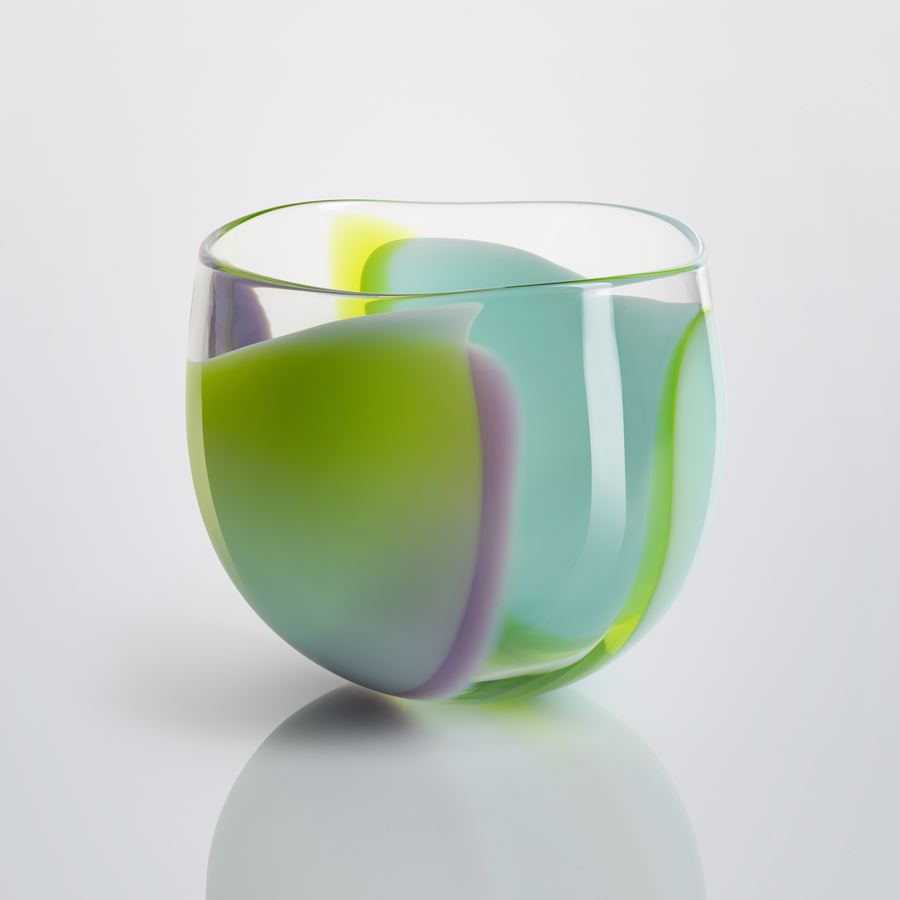 tulip flower shaped hand blown clear glass bowl with swirling merging bands and sections of colour in opaque lime purple and aquamarine blue 