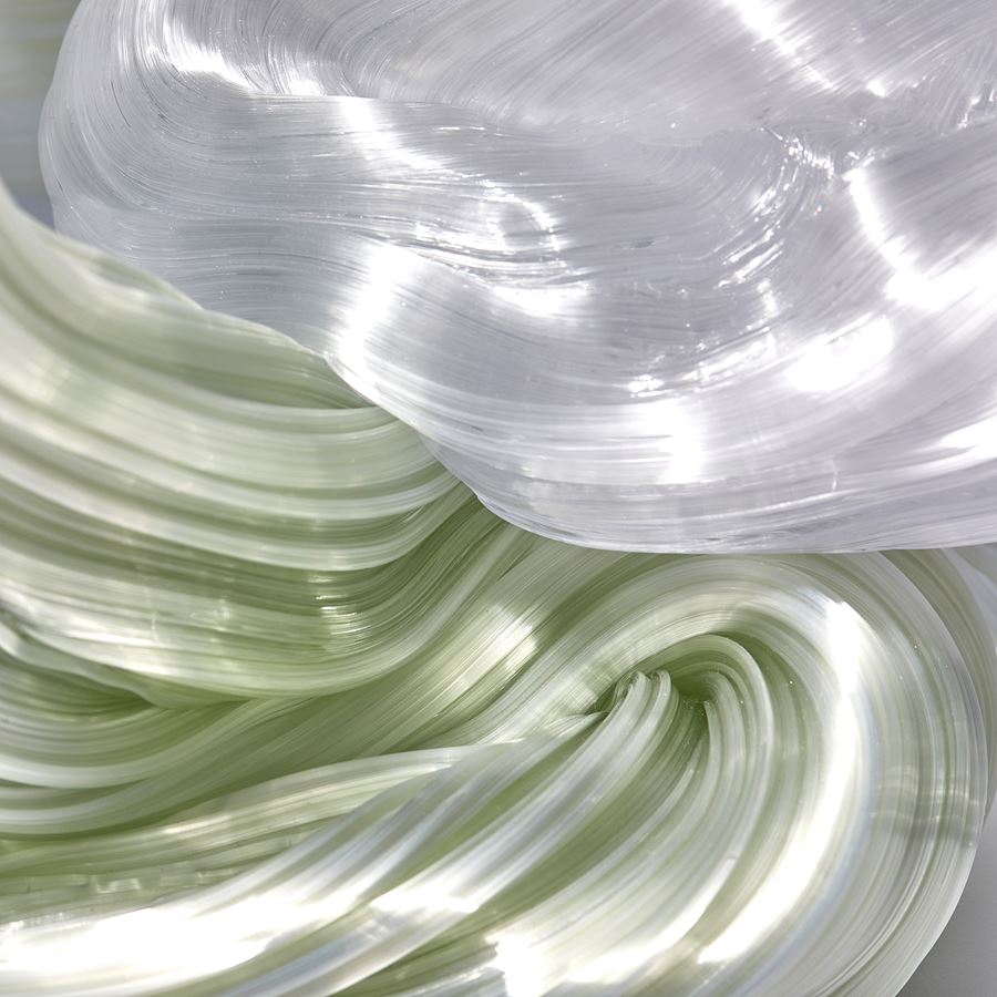 piled mass of ridged winding lime green and white rope like candy strands hand made from glass
