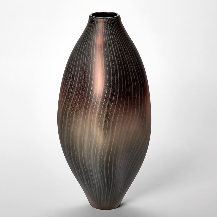 tall oval vessel in metallic aubergine grey and gold with fine white lace like patterns across the entire surface hand made from glass