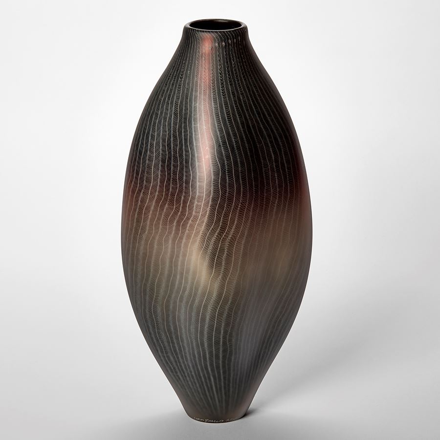 tall oval vessel in metallic aubergine grey and gold with fine white lace like patterns across the entire surface hand made from glass