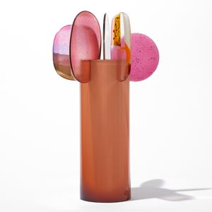 opaque orange cylinder with five rounded finials overlapping and perched on the top edge with abstract patterns in pink gold white and clear hand made from blown and fused glass