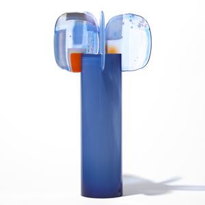 cornflower blue cylinder with five rounded abstract petal forms perched on top with patches of colour in red blue lilac and yellow hand made from blown and fused glass