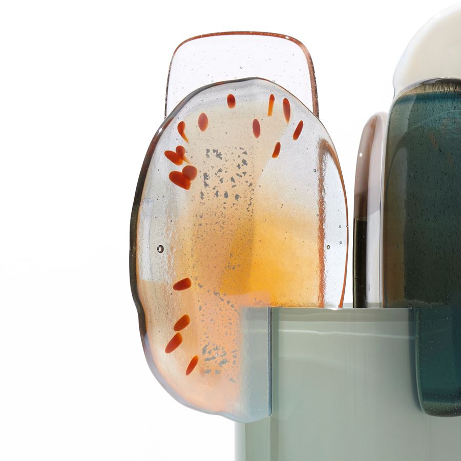 rich green grey cylinder with colour fade towards the top with five rounded abstract finials overlapping the top edge in orange steel opaque white and clear hand made from blown and fused glass