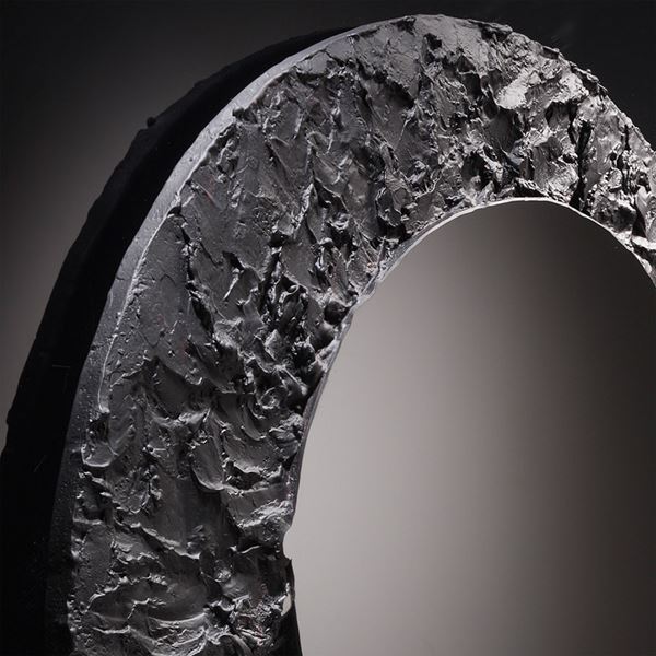 round black mirror glass artwork with cratered edge