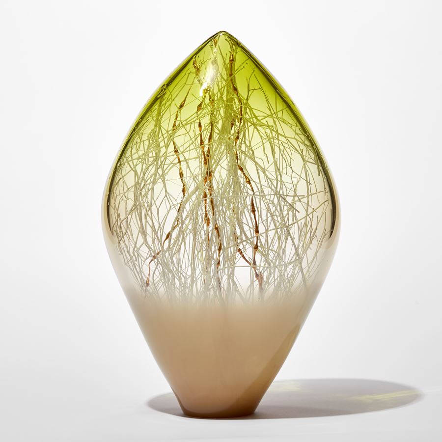clear and opaque standing glass sculpture with pointed top in light bronze and lime green with fine white canes trapped inside mixed with gold ones with bulbous rounded sections