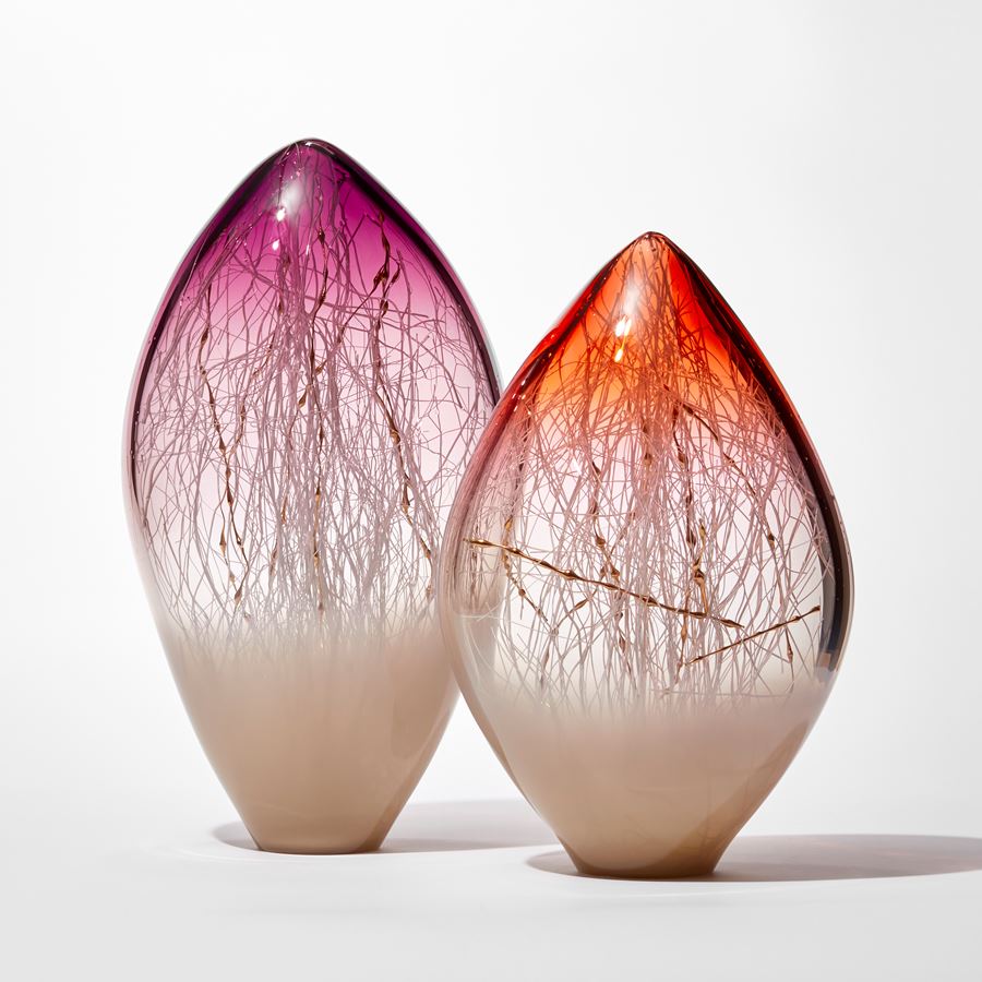 opaque and transparent pointed ovoid standing glass sculpture with soft bronze base and rich orange red top with fine white canes trapped inside intermingled with gold ones with bulbous sections