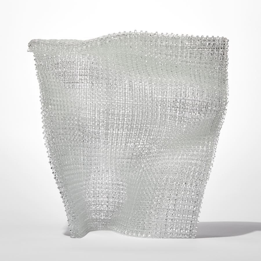 standing undulating clear woven glass sculpture with the appearance for textiles made from layered and fused thin canes of glass