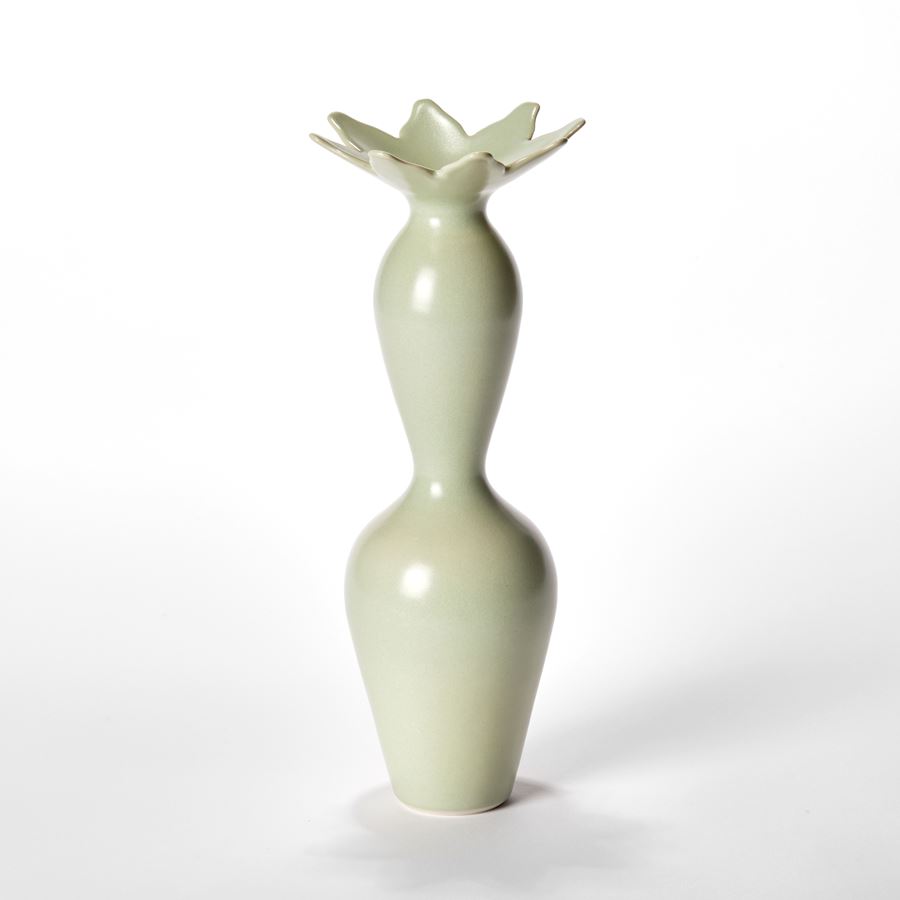 group of three porcelain vases with undulating forms in soft green with abstract cactus flowers around the top rims
