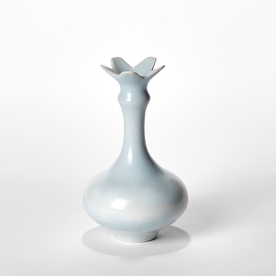 trio of turquoise elegant porcelain vases with long elegant necks rounded bases and star floral widening rims