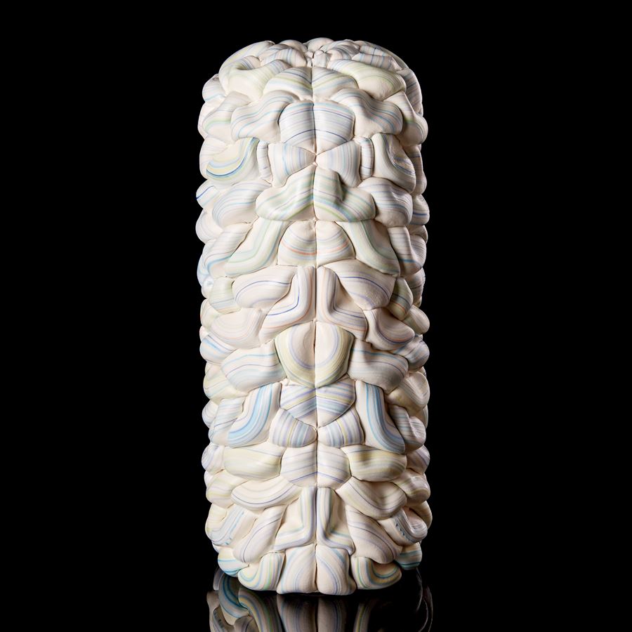 sculptural column vessel made of stacked interwoven ridged white rings with bands of pastel colours with central front seam and both halves mirroring each other