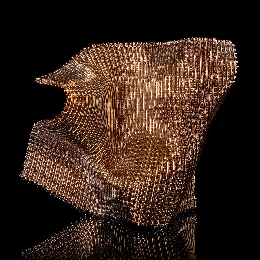 standing undulating glass sculpture with the appearance of open woven cloth with one side covered in gold hand made from fused find glass canes