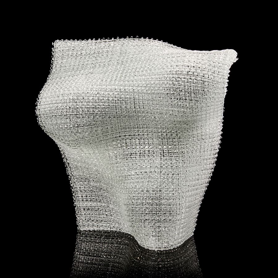 standing undulating clear woven glass sculpture with the appearance for textiles made from layered and fused thin canes of glass