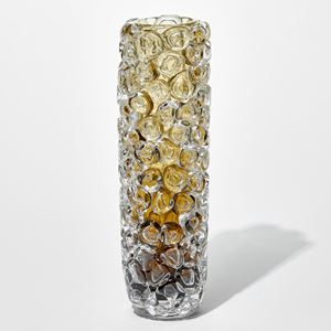 tall column shaped transparent vase with dark brown base fading to rich amber and olive at the top with the outside covered in oversized squished bubbles hand made from glass