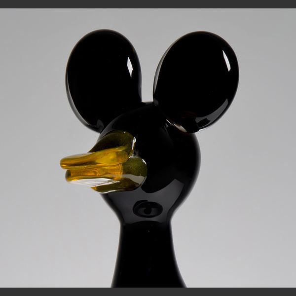 decorative blown glass ornament of a cartoon duck with steel legs and base