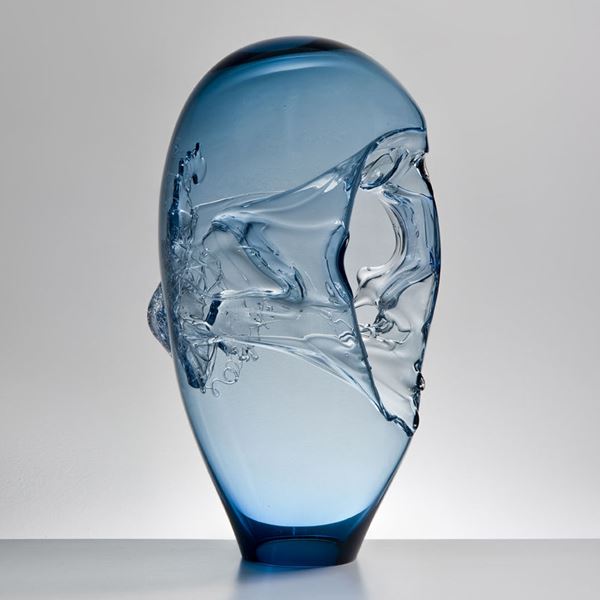 light blue seethrough oblong-shaped glass-art sculpture vessel with handle and abstract pattern