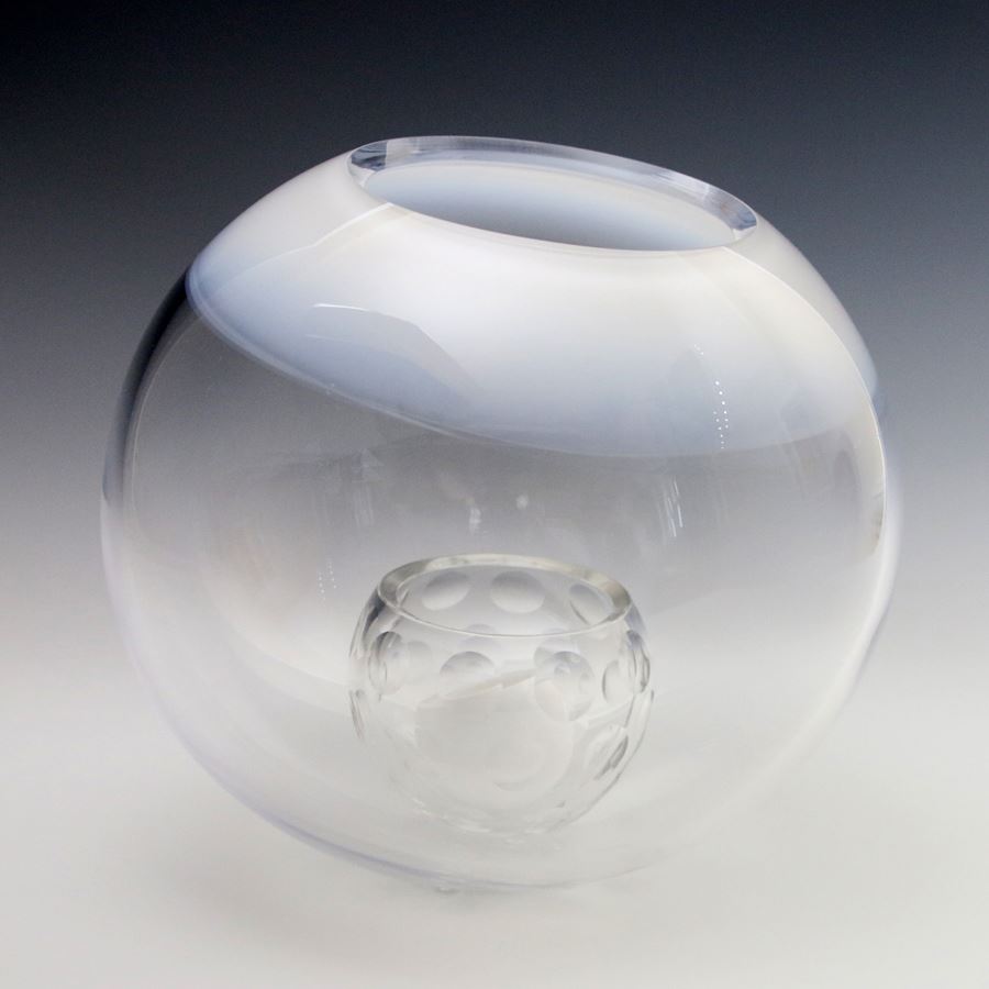 clear glass sculpture artwork of small round ball inside larger ball