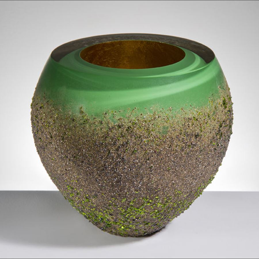 modern glass vase sculpture with open top in green swirls coated in earthy brown speckles from bottom to near top