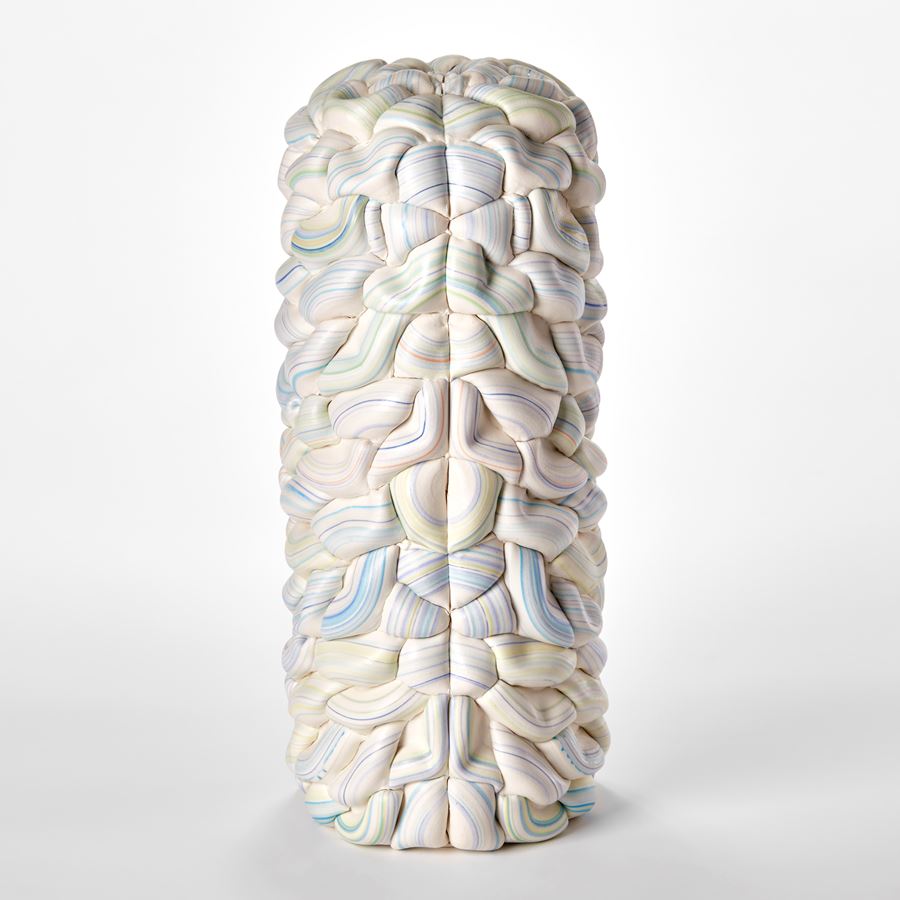 sculptural column vessel made of stacked interwoven ridged white rings with bands of pastel colours with central front seam and both halves mirroring each other