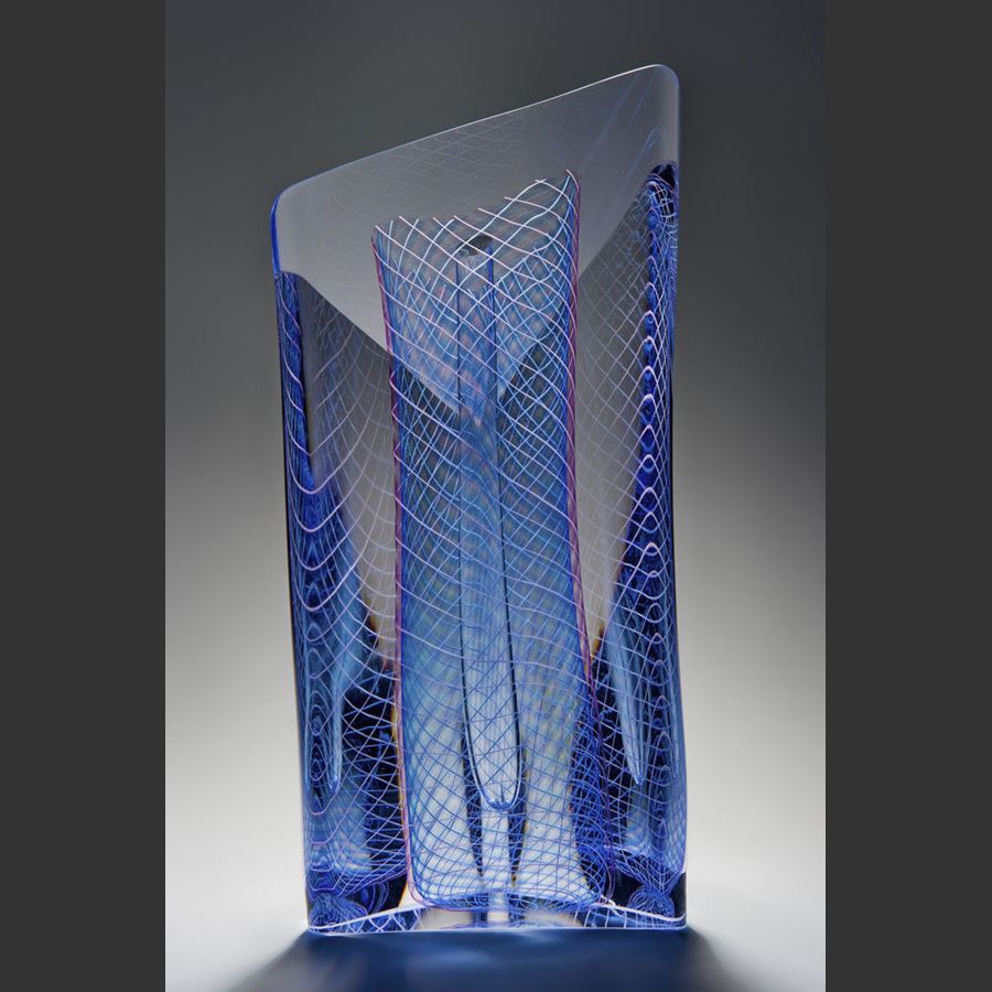 art glass sculpture with blue mesh pattern in dress shape caged in outer clear glass structure