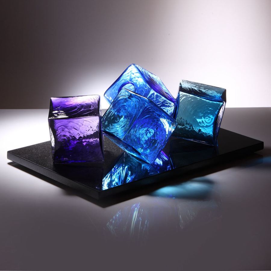 artwork of light and dark blue and purple glass cubes on black rectangular base