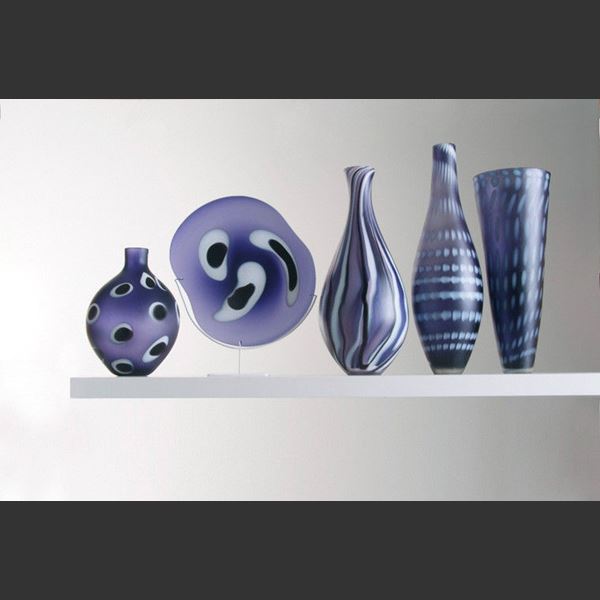 five purple hand blown glass vases in different shapes and patterns