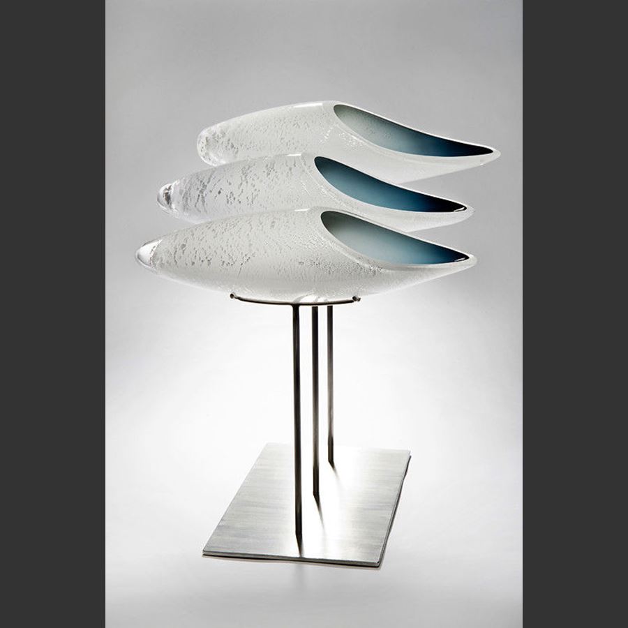 three fish shaped white glass sculptures on metal base