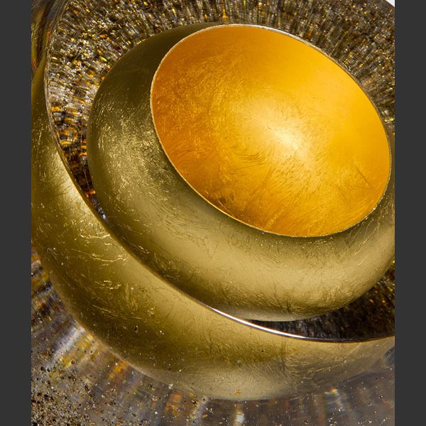 contemporary art glass sculpture of a sphere in earthy colours and layers showing golden core