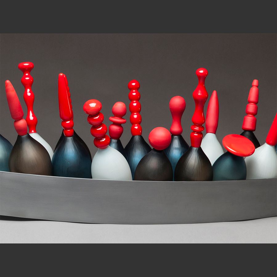 artwork of red topped glass skittles in long steel tray