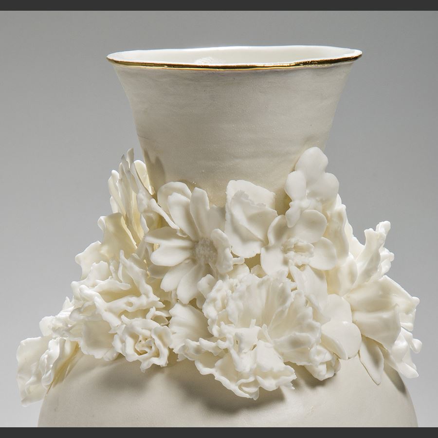 modern ceramic vase sculpture of a classical style in white with flowers sculpted at neck