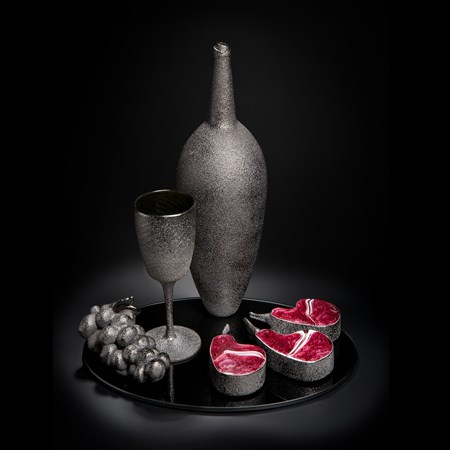 still life artwork of bowl glass grapes and cut fruit in black and dark flesh colours made from handblown and sculpted glass