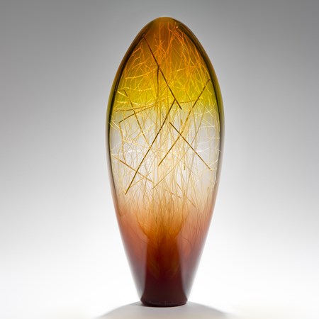 tall curved amber and coffee coloured glass sculpture with delicate nature-inspired internal structure 