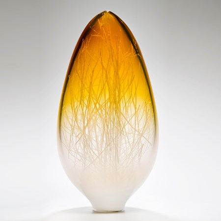 tall sculpted glass vessel in amber and white which wire interior resembling bare tree branches