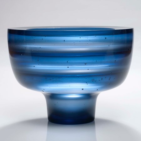 sculpted glass bowl with thin base in horizontal lined blue pattern