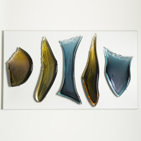 wall mounted glass art sculpture of primitive tool like shapes in dark blue and yellow