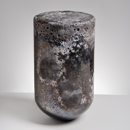 glass sculpture made to resemble natural stone with dark and light earthy tones in the shape of a bullet