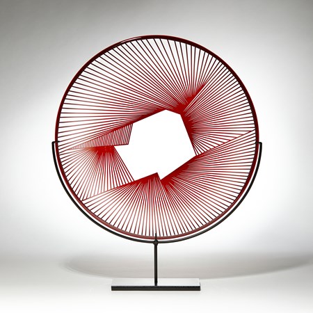 red and clear round sculptural glass plate made from handblown and cut glass with metal stand