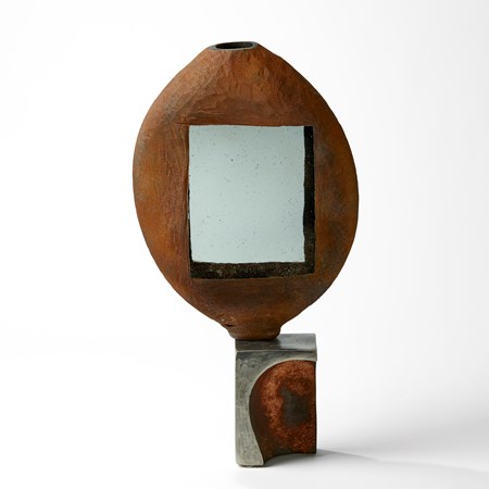 rust ovoid vessel with grey rectangular windows on a steel base handblown from glass