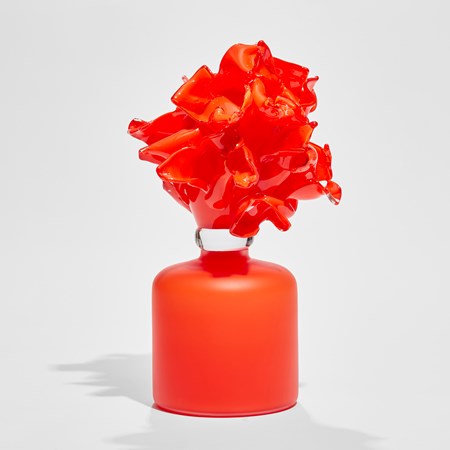 bright orange frosted rounded base with bursting abstract floral mass on top hand made from glass