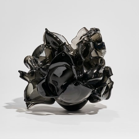 black flower vase with petals in different abstract organic shapes attached to a ovoid base hand made from glass