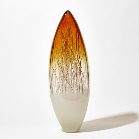tall pointed oval sculpture with light cream base clear middle and bright amber gold top containing thin strands in white and gold hand made from glass