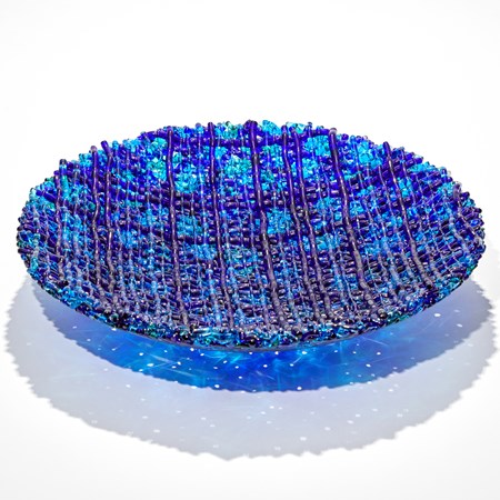 woven curved bowl with raised lines in differing blues hand made from glass