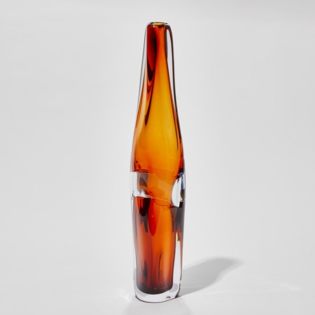 tall soft and undulating rich amber and clear vase hand made from glass