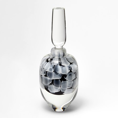 round clear bottle with long stopper with encased abstract pattern in black and white hand made from glass