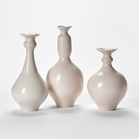 soft pastel pink trio of porcelain bottles with rounded bases thinning necks and flared rims hand thrown