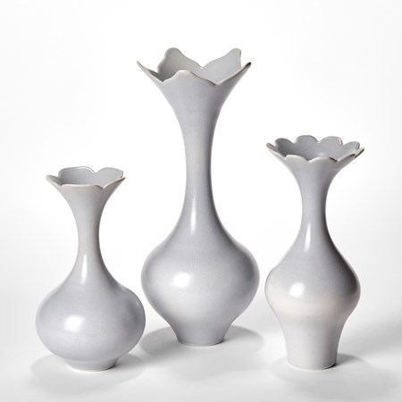 soft dove grey set of three elegant porcelain vases with rounded lower sections long sinuous necks and flared rims with abstract floral cutout edges