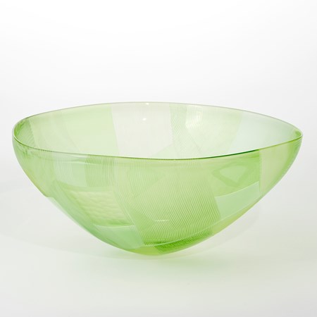 vibrant handblown round bowl with small foot and sweeping wide opening rim with both surfaces covered in abstract cut landscape inspired patterns